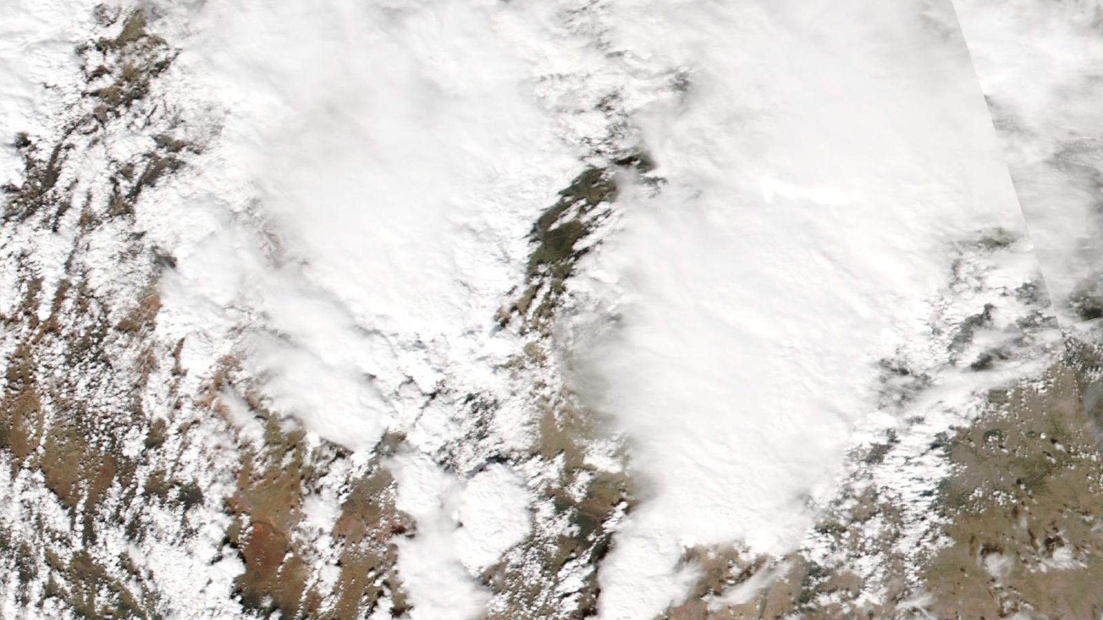 Satellite image of the Four Corners area with a thick white mass of storm clouds covering much of the land.